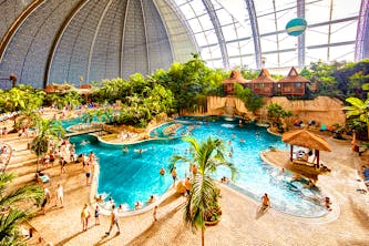 Tropical Island Resort nähe Berlin von innen fotografiert - tropische und karibische Atmosphäre mit Palmen, Strandhäusern wie in Hawaii und Wellengang im Poolbereich mit kleinem Wasserfall