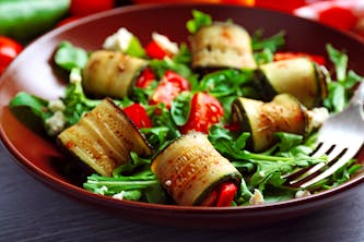 Ein köstlich angerichtetr Teller mit vegetarischem Essen für das Wellness Wochenende - Zuchini Tomaten Rucola und Parmesan Antipasti Gericht und gesund für die schlanke Linie