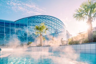 Therme Erding Erlebnisbad in der N&auml;he von M&uuml;nchen mit Palmen und S&uuml;dseeambiente und viel Platz zum schwmmen, mit Liegem&ouml;glichkeiten am Wasser oder bei den Whirlpool-D&uuml;sen - auf dem Bild ist scheinbar noch wenig los in der Therme - so kann man am besten entspannen